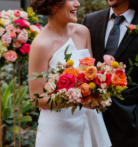 Primary Pop Bride and Groom with orange, pink, yellow and peach flowers with bride and groom