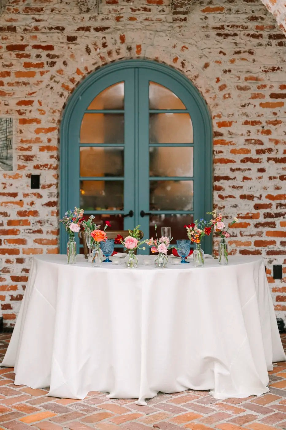 Real Poppy wedding reception styled with cafe lighting and lush floral centerpieces